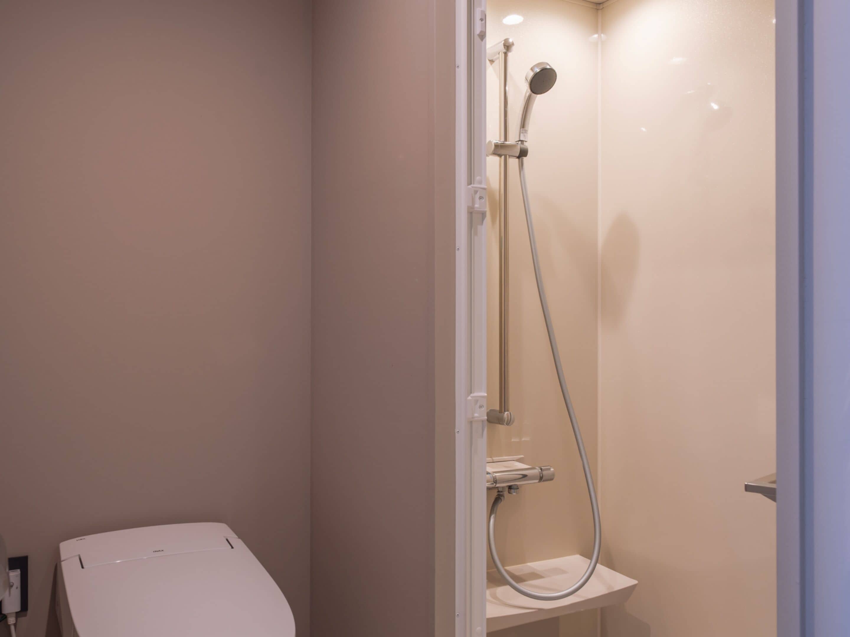 Une petite salle de bain moderne, équipée d’une douche, de toilettes et d’un lavabo.
