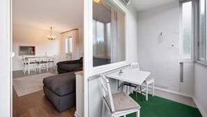 Une pièce moderne avec une table blanche, un canapé gris et un tapis vert.