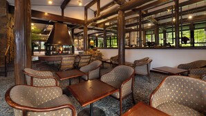 A restaurant with wooden beams, patterned chairs, and tables. - Yatsugatake Kogen Lodge (Minamimaki)