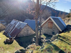 A row of stone cottages with sloped roofs, surrounded by a rocky landscape and a clear sky. - La Maison Victoire - Roquebillière (Roquebillière)