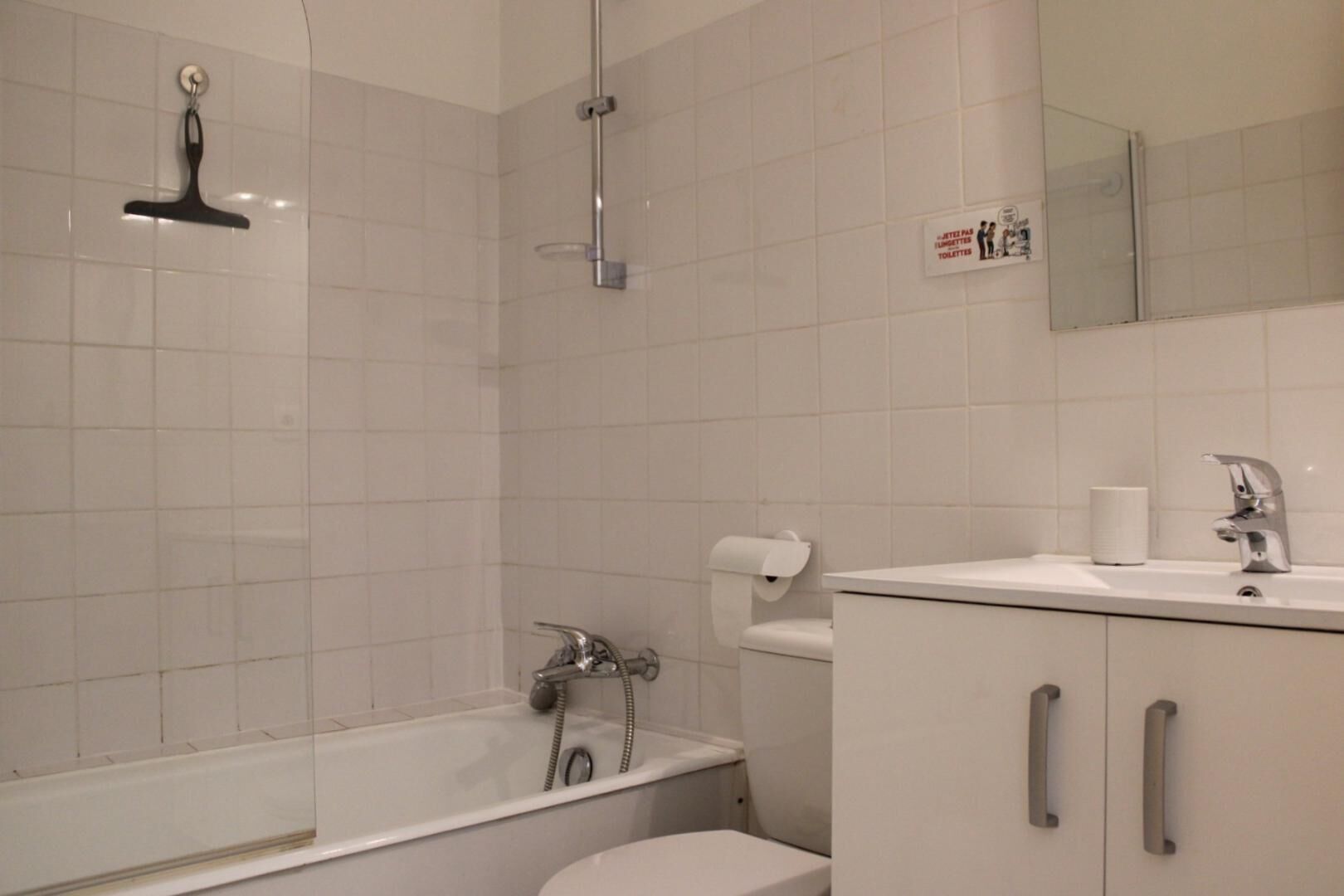 A modern bathroom with a shower, toilet, and sink.