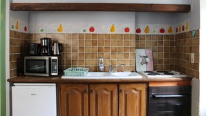 A kitchen with a microwave, coffee maker, sink, and stove. - La Maison Commune - CAILLE (CAILLE)