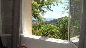 A room with a view of a green landscape through a window. - L'Olivier de St Paul (SAINT-PAUL-DE-VENCE)