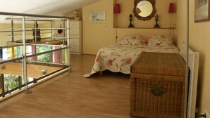 Un dormitorio con cama, cómoda, espejo y ventana.
