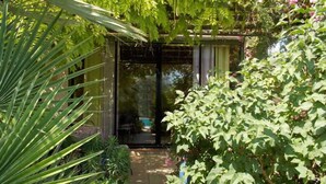 Un jardín con una puerta de cristal que da a una habitación.