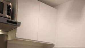 A compact kitchen with a built-in oven, dishwasher, and a coffee maker on the counter.