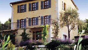 A two-story building with a balcony, surrounded by greenery and a clear sky. - L'Oustaou - La Colle-sur-Loup (La Colle-sur-Loup)