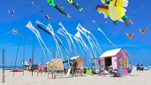 A beach with colorful kites, tents, and beach chairs. - Hotel Les Augustines (Quend)