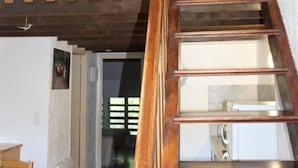 Una escalera de madera con barandilla que conduce a un nivel superior.