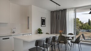 Een moderne keuken met een centraal eiland, barkrukken en een eethoek met uitzicht.