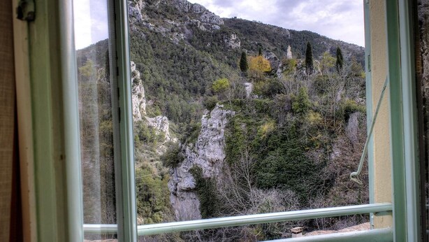 A view through a window of a mountainous landscape with rocky cliffs and sparse vegetation. - Le Balcon - PEILLE - Gîte (PEILLE)
