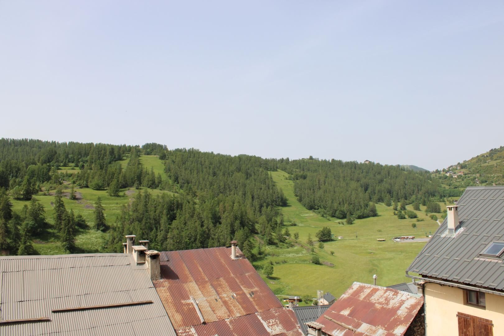 Una zona residencial con casas y una ladera boscosa.