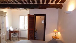 A bedroom with a bed, a desk with a laptop, a chair, a lamp, and a wardrobe. - Bastide de la Rousoulina (LE ROURET)