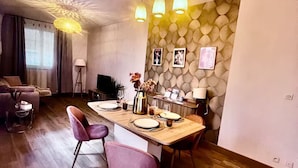 Un salon moderne avec une table à manger en bois, des chaises violettes et un canapé.
