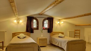 A bedroom with two wooden beds, a nightstand with a vase, and a window with curtains. - La Maison Blanche - BLAUSASC (BLAUSASC)
