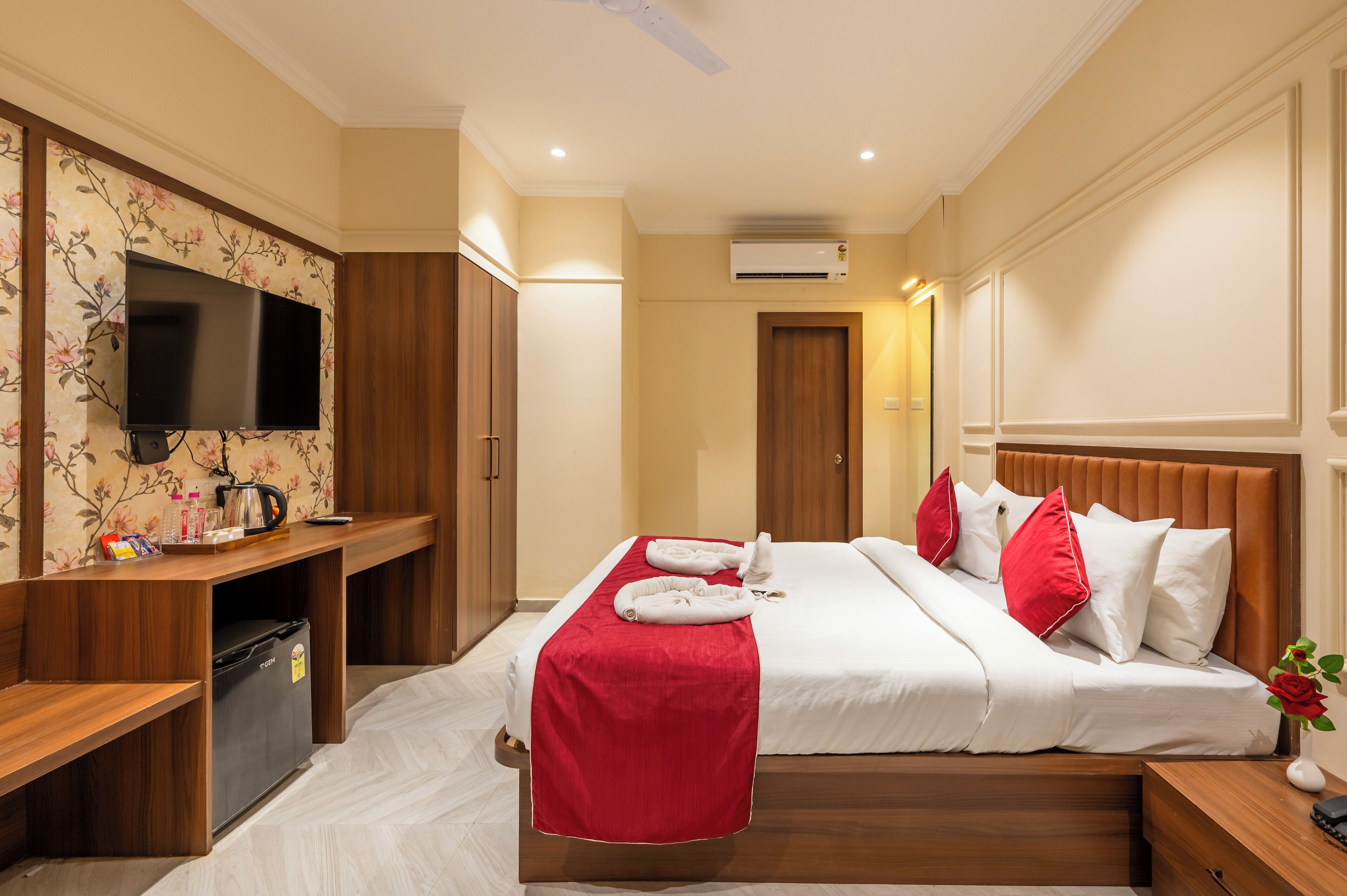 Una habitación de hotel con cama, televisión, escritorio y armario.
