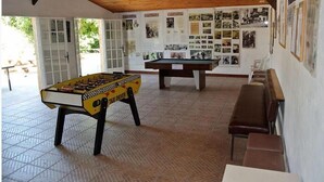 A room with a foosball table, a pool table, and a bench along the wall. - Riola Farm - Gîte n°6004 (Contes)