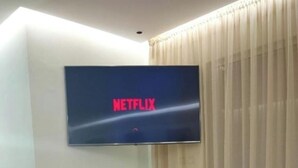 A living room with a flat-screen TV mounted on the wall displaying the Netflix logo. - Luxury Villa Hay Ryad (Rabat)