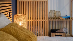 A neatly arranged bedroom with a bed, a bedside lamp, and a shelf with books and decorative items. - Luce del Mare by Interhome (Valledoria)
