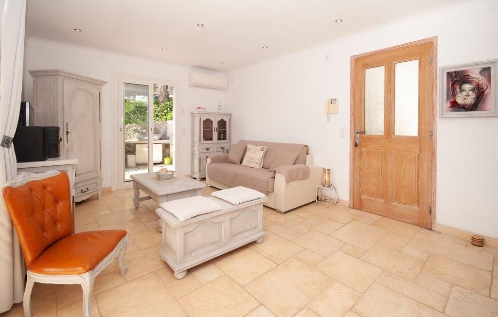 Un salon comprenant un canapé, un fauteuil et une table basse, ainsi qu’une armoire et une porte.