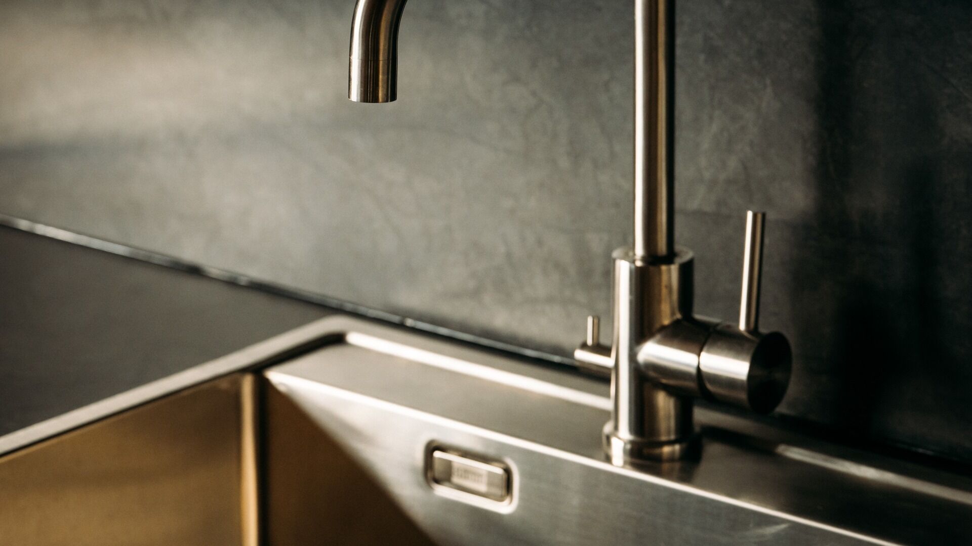 Una cocina moderna con un grifo de acero inoxidable, un cajón y un reverso con textura.