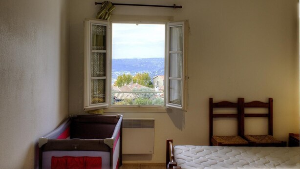 A bedroom with a window, a bed, a small table, and a radiator. - Espace des Oliviers - Gîte n°2 (CASTAGNIERS)