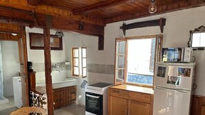Une cuisine de taille réduite, avec des meubles en bois, un fourneau blanc, un réfrigérateur et un four à micro-ondes.