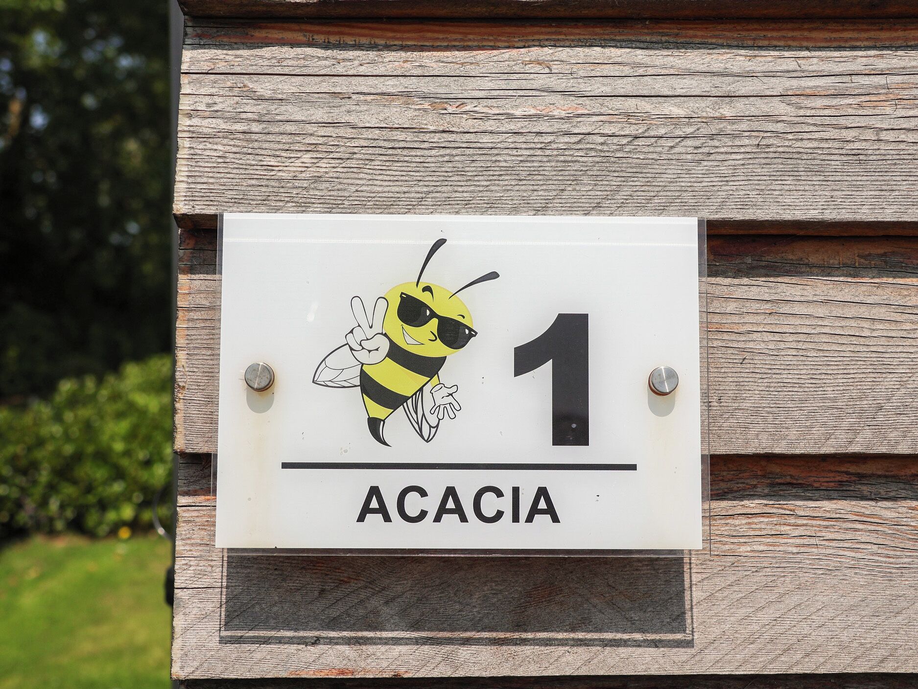 A sign with a bee illustration and the number 1, mounted on a wooden structure.