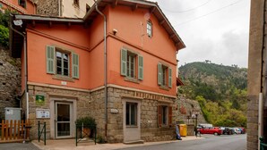 A two-story building with a stone facade and green shutters, labeled "Mediatheque."
