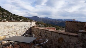 A stone terrace with a table and chairs, overlooking a mountainous landscape. - Le Ciste - SAINT-JEANNET (SAINT-JEANNET)