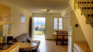 Una sala de estar acogedora con sofá, una mesa de comedor y zona de cocina.