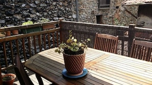 A wooden table with a potted plant in the center, surrounded by wooden chairs.