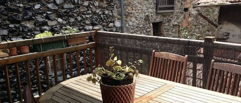 Uma mesa de madeira com uma planta em vaso no centro, rodeada por cadeiras de madeira.