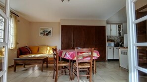 A living room with a sofa, a dining table with chairs, a kitchen area with cabinets and appliances, and a large wooden wardrobe. - Ascent from St. Jean d'Ermi to BREIL-SUR-ROYA (BREIL-SUR-ROYA)