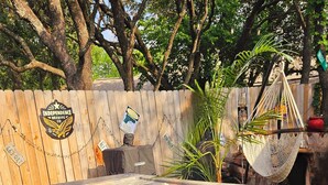 A hot tub with a wooden deck and a hammock.