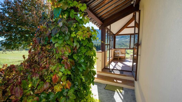 A covered outdoor seating area with a view of a mountainous landscape. - Laure-Anne - SAINT-AUBAN (SAINT-AUBAN)