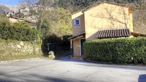 A residential building with a tiled roof, a small window, and a stone wall.