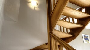 A wooden staircase with a light fixture on the wall.
