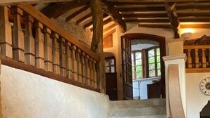 A stone staircase with wooden railings and a rustic ceiling.