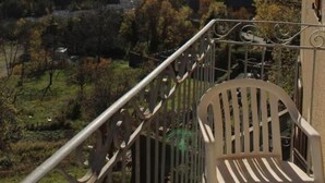 A balcony with a view of a valley and mountains.