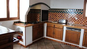 A kitchen with wooden cabinets, a stove, and a tiled backsplash.