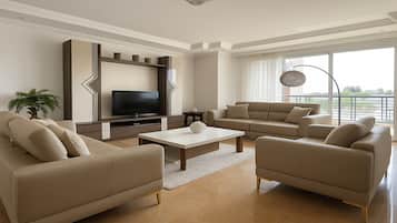 A modern living room with a flat-screen TV, two sofas, a coffee table, and a large window with a balcony view.