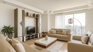 A modern living room with a flat-screen TV, two sofas, a coffee table, and a potted plant. - Spacieux Appartement à Hydra (Timokten)