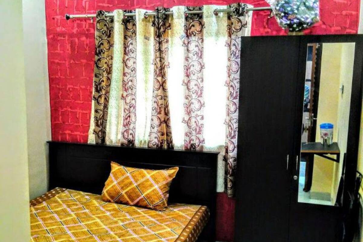 Un dormitorio con cama, armario y espejo.