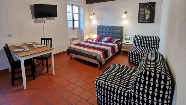 Une chambre à coucher avec un lit, une télévision, un bureau et une chaise.