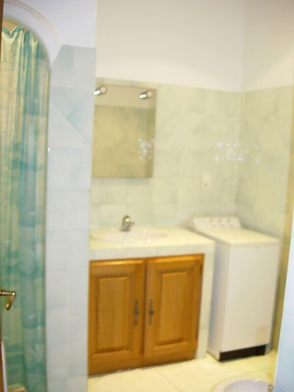 A bathroom with a shower, a sink, and a toilet.