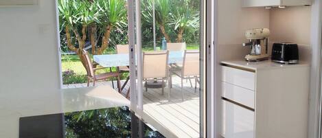 A modern kitchen with a sliding glass door leading to an outdoor patio area.