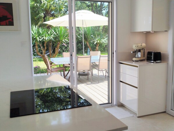 A modern kitchen with a sliding glass door leading to an outdoor patio area.