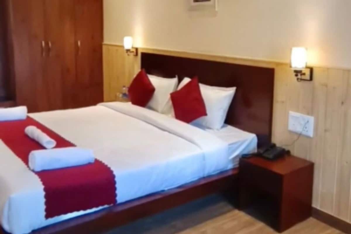 Ein Hotelzimmer mit einem großen Bett, zwei Nachttischen und einem Holzschrank.