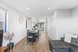 A modern interior with a dining area, kitchen, and seating space. - Stylish 4BR Townhouse in Suburbs by Zodiak (Auckland)